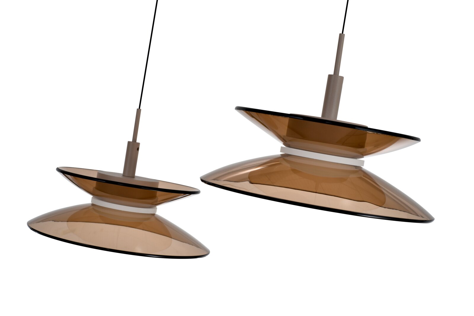 Twee moderne hanglampen met dubbele, amberkleurige glazen kappen en zwarte snoeren, schuin van onderen gezien tegen een witte achtergrond