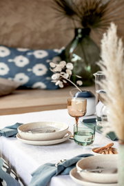 Ein stilvoll gedeckter Tisch mit einem Weinkelch aus einem 2-teiligen Set, in einer gemütlichen und eleganten Atmosphäre. Perspektive: seitlich.