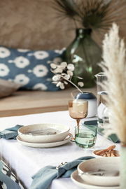 Ein stilvoll gedeckter Tisch mit einem Weinkelch aus einem 2-teiligen Set, in einer gemütlichen und eleganten Atmosphäre. Perspektive: seitlich.