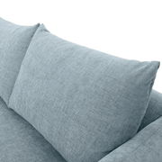 Nahaufnahme eines hellblauen Sofakissens mit strukturiertem Stoff, Perspektive von oben.