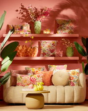 Gemütliche Couch mit bunten Kissen und dekorativen Vasen, frontal fotografiert.