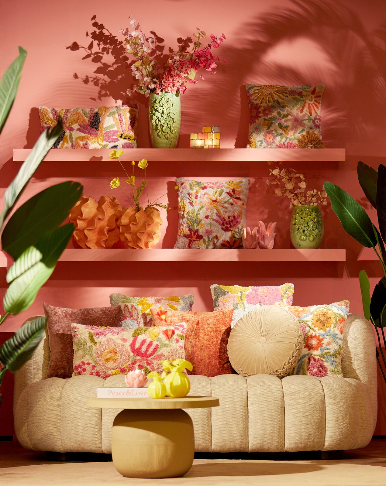Gemütliche Couch mit bunten Kissen und dekorativen Vasen, frontal fotografiert.