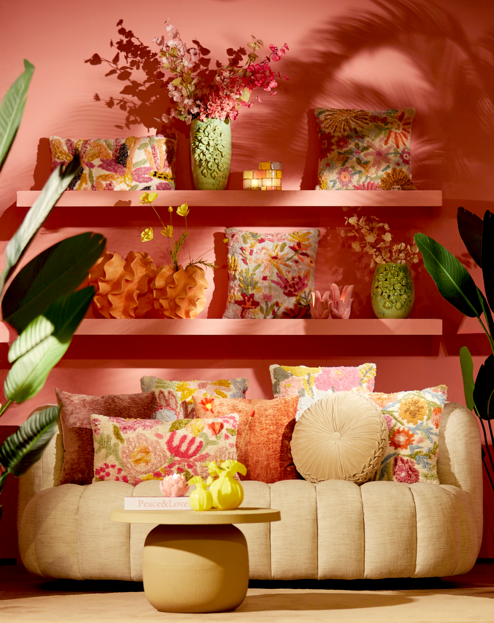 Gemütliche Couch mit bunten Kissen und dekorativen Vasen, frontal fotografiert.
