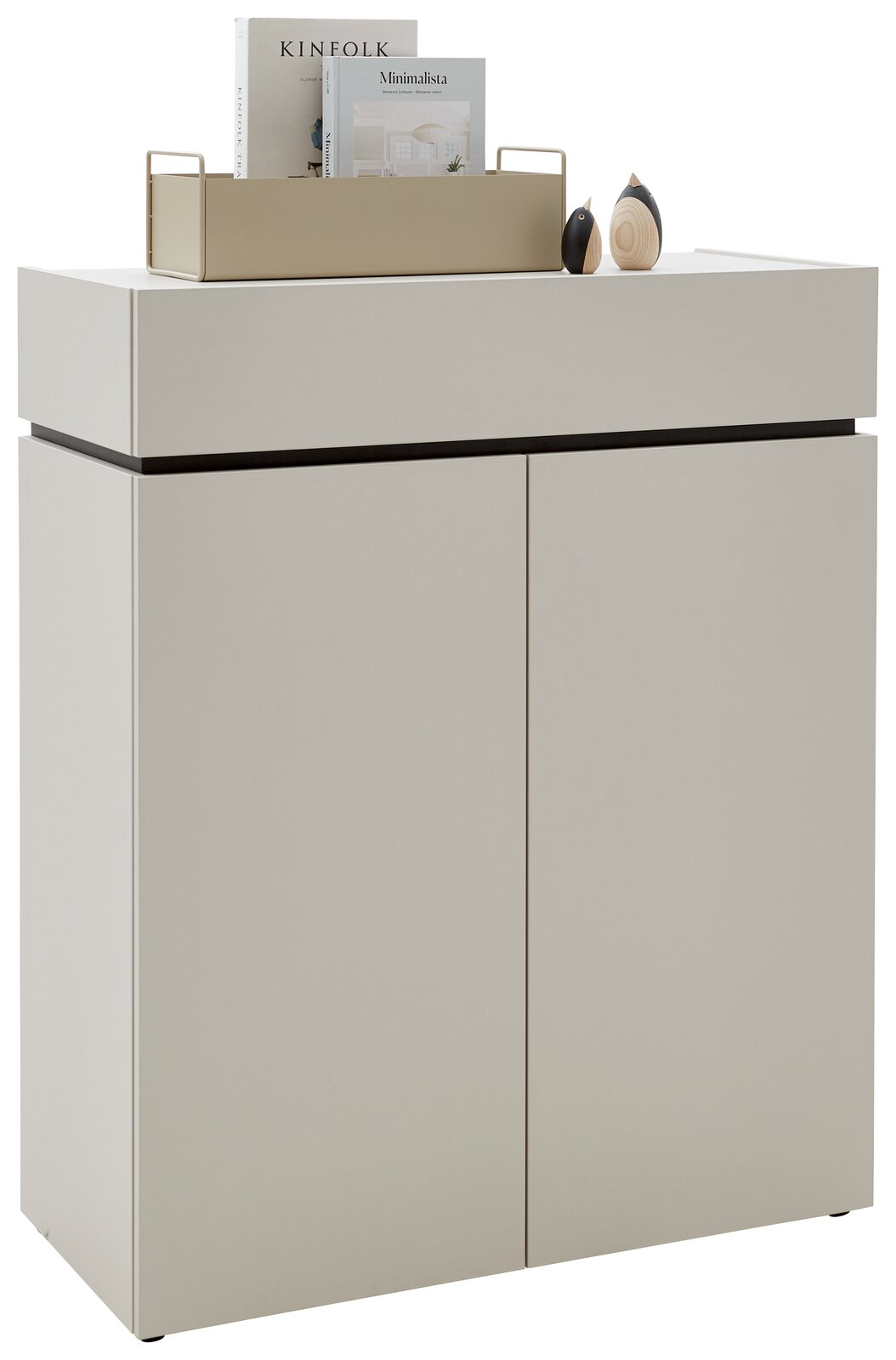 Voleo Kommode UNIQUE Moderne Kommode in hellem Beige mit zwei Türen, dekoriert mit Büchern und kleinen Skulpturen auf der Oberseite, seitliche Perspektive