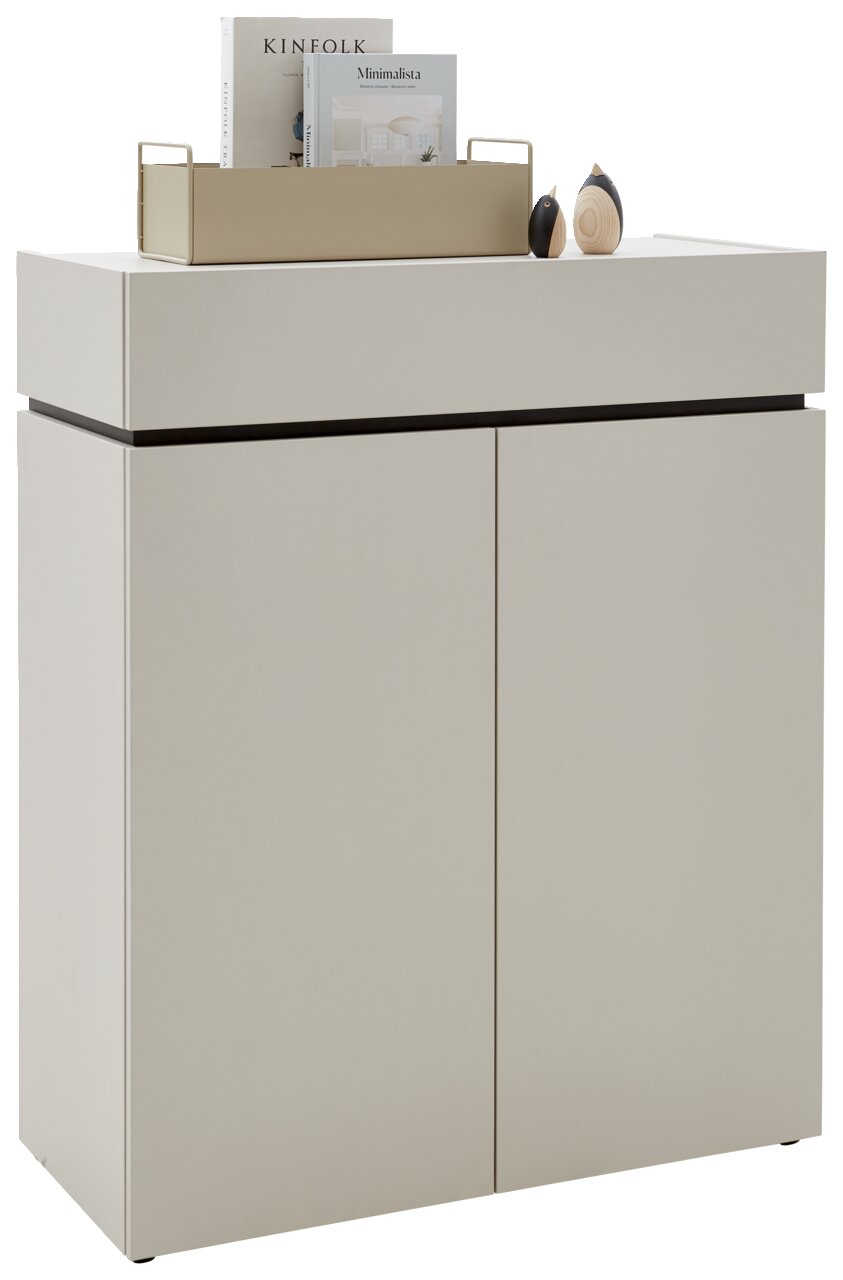 Voleo Kommode UNIQUE Moderne Kommode in hellem Beige mit zwei Türen, dekoriert mit Büchern und kleinen Skulpturen auf der Oberseite, seitliche Perspektive
