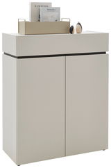 Moderne Kommode in hellem Beige mit zwei Türen, dekoriert mit Büchern und kleinen Skulpturen auf der Oberseite, seitliche Perspektive