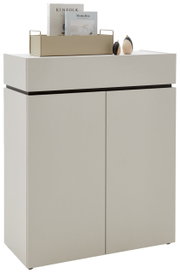 Moderne Kommode in hellem Beige mit zwei Türen, dekoriert mit Büchern und kleinen Skulpturen auf der Oberseite, seitliche Perspektive