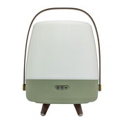 Rückansicht einer tragbaren Lampe mit grünem Sockel, weißem Lampenschirm und braunem Tragegriff, auf drei Holzbeinen stehend.