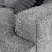 Graues Ecksofa mit strukturierter Oberfläche, Nahaufnahme der Armlehne von der Seite.