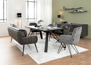 Moderner Esstisch mit schwarzer Tischplatte und Metallbeinen, umgeben von stilvollen Stühlen in einem hellen, eleganten Esszimmer. Perspektive von der Seite.