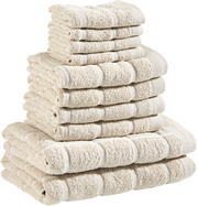 Ein Stapel beiger Frottierhandtücher in verschiedenen Größen, von der Seite betrachtet.