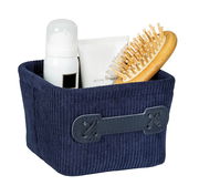 Dunkelblauer, quadratischer Badkorb Anela mini mit gerippter Textur, gefüllt mit Pflegeprodukten und einer Holzbürste, aus leicht schräger Perspektive fotografiert.
