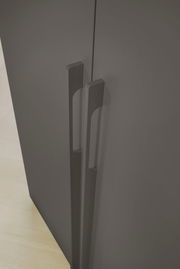 Nahaufnahme der Griffe eines grauen Drehtürenschranks aus der Vogelperspektive.