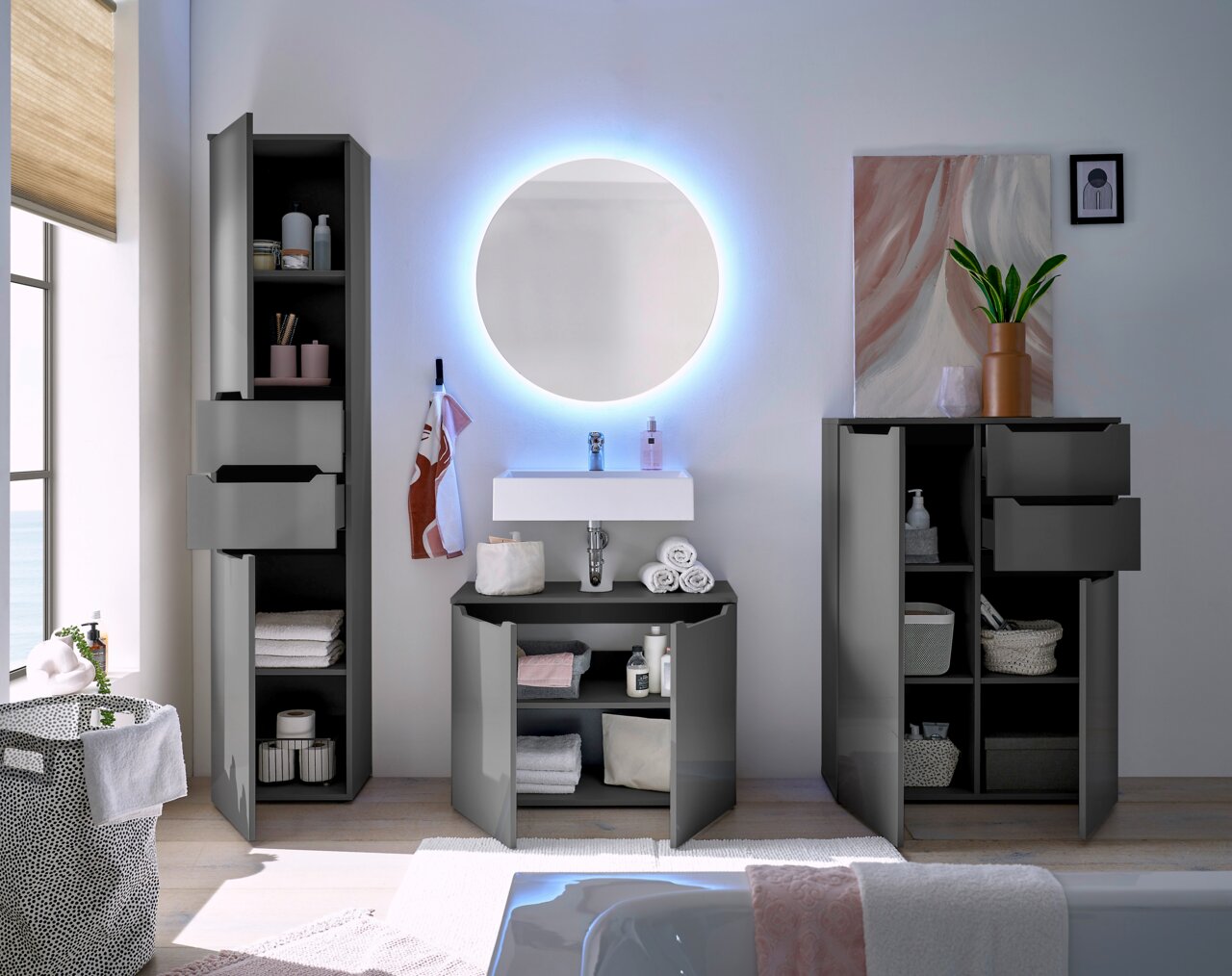 Modernes Badezimmer mit grauem Highboard, Spiegelschrank und Waschbecken, frontal betrachtet.