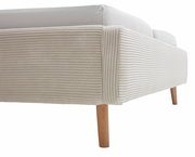 Nahaufnahme eines Polsterbetts mit beigem, geripptem Stoffbezug und Holzbeinen, seitliche Perspektive