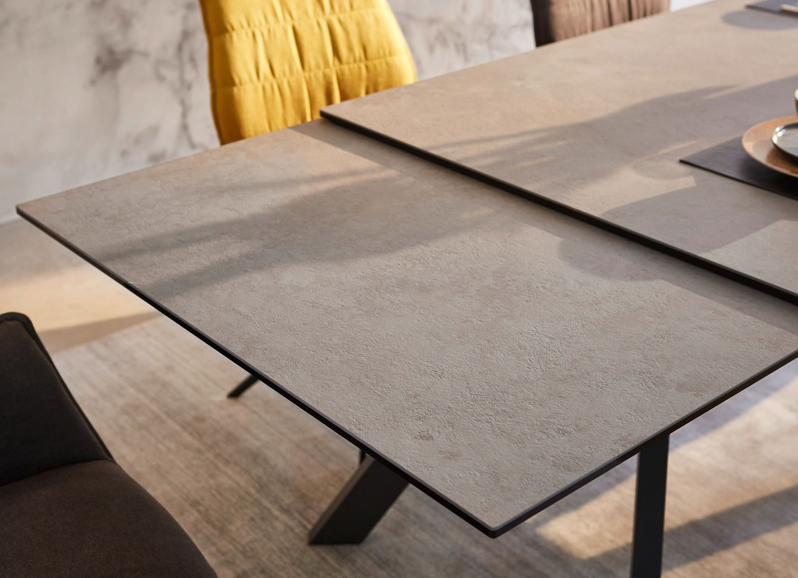 Moderner Esstisch mit grauer Steinoptik-Oberfläche, seitliche Perspektive