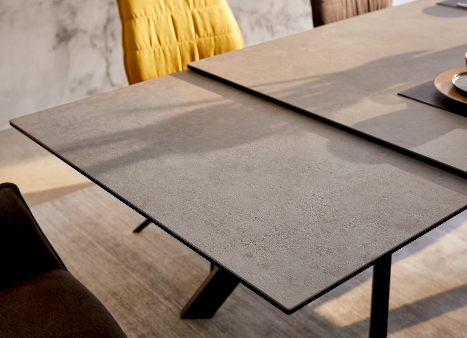 Moderner Esstisch mit grauer Steinoptik-Oberfläche, seitliche Perspektive