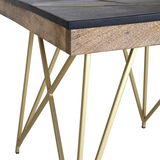 Nahaufnahme eines Beistelltisches mit schwarzer Holzplatte und goldenen Metallbeinen in geometrischem Design, seitliche Perspektive