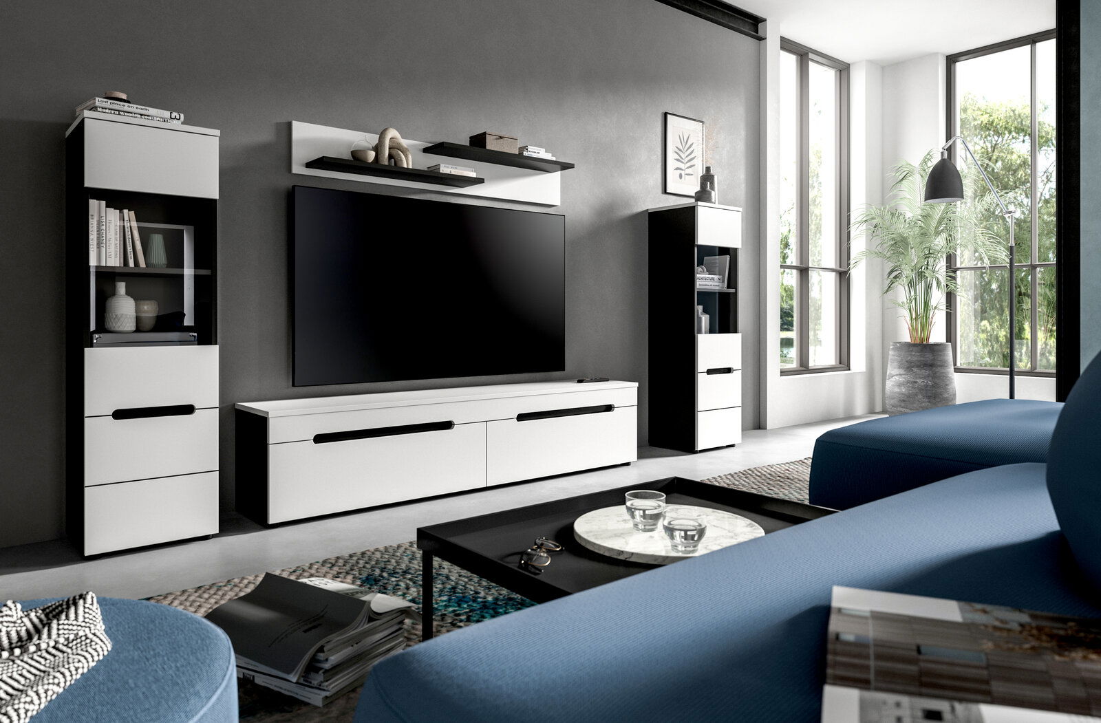 MID.YOU Wohnkombination CANU Modernes Wohnzimmer mit weiß-schwarzer TV-Wand (Lowboard, zwei Vitrinenschränke und Wandregal) und großem Flachbildfernseher, fotografiert in frontaler Perspektive leicht von rechts.