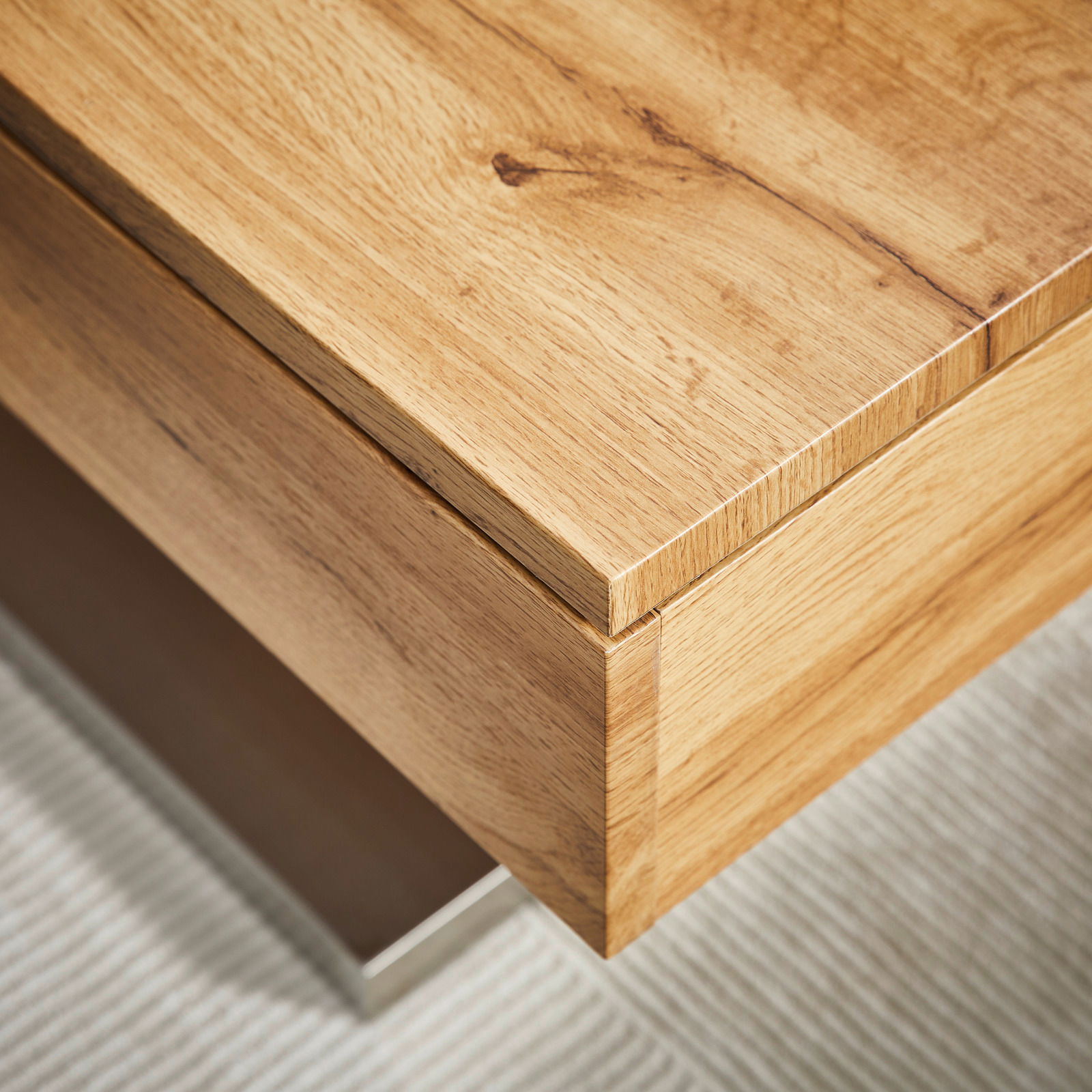 Nahaufnahme eines Couchtischs aus Holz mit natürlicher Maserung, perspektivisch von oben fotografiert.