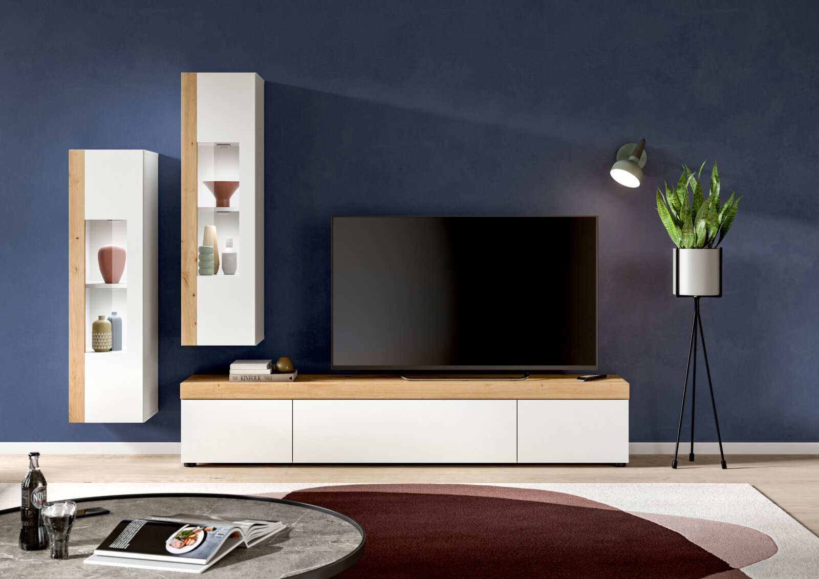 Moderne Wohnzimmer-Vitrine in Weiß und Holzoptik, frontal betrachtet, mit dekorativen Objekten und einem großen Fernseher.