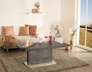 Moderner Couchtisch in Betonoptik, zentral im Wohnzimmer platziert, umgeben von stilvoller Dekoration und einem großen Fenster mit Blick ins Freie.