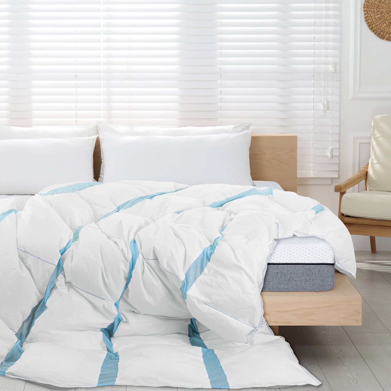 Weiße, voluminöse Bettdecke mit hellblauen Streifen auf einem Holzbettrahmen im hellen Schlafzimmer, Perspektive: frontale Ansicht leicht von oben.