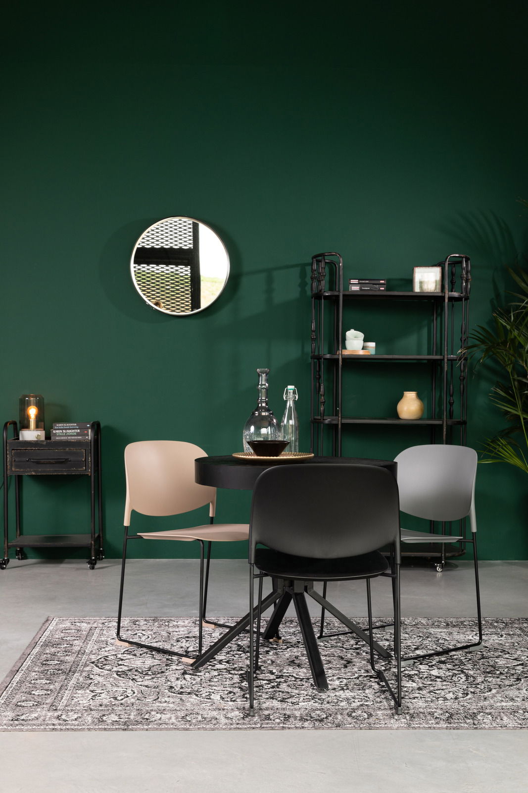 Drei moderne Stühle in verschiedenen Farben um einen runden Tisch, mit Blick auf die Vorderseite der Stühle.