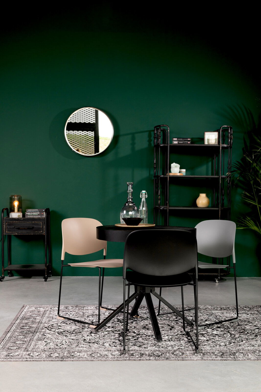 Drei moderne Stühle in verschiedenen Farben um einen runden Tisch, mit Blick auf die Vorderseite der Stühle.