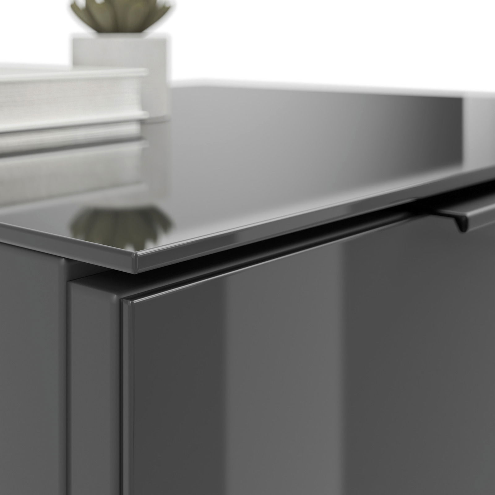 Nahaufnahme einer modernen, glänzenden Nachtkommode in dunkler Farbe mit einer Pflanze und Büchern darauf, aus seitlicher Perspektive.