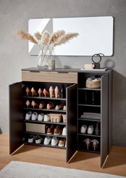 Moderne schwarze Schuhkommode mit Holz-Lamellenfront, geöffnete Türen mit mehreren Schuhfächern und Seitenregal, Frontansicht in leicht schräger Perspektive im Flur unter einem Wandspiegel