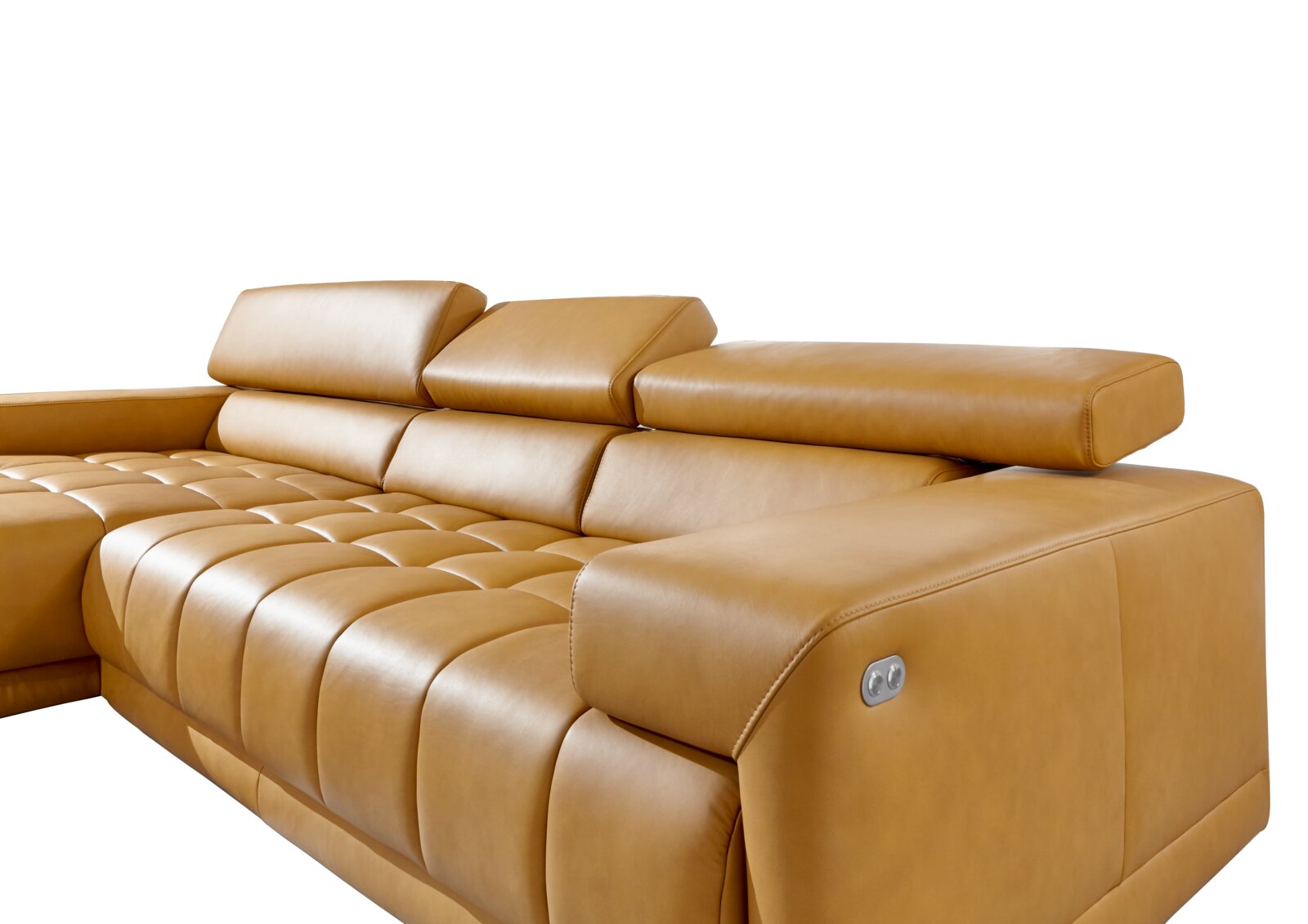 Close-up van een moderne, beige lederen ligstoelcombinatie met verstelbare hoofdsteunen en elegante stiksels, gezien vanaf de zijkant.