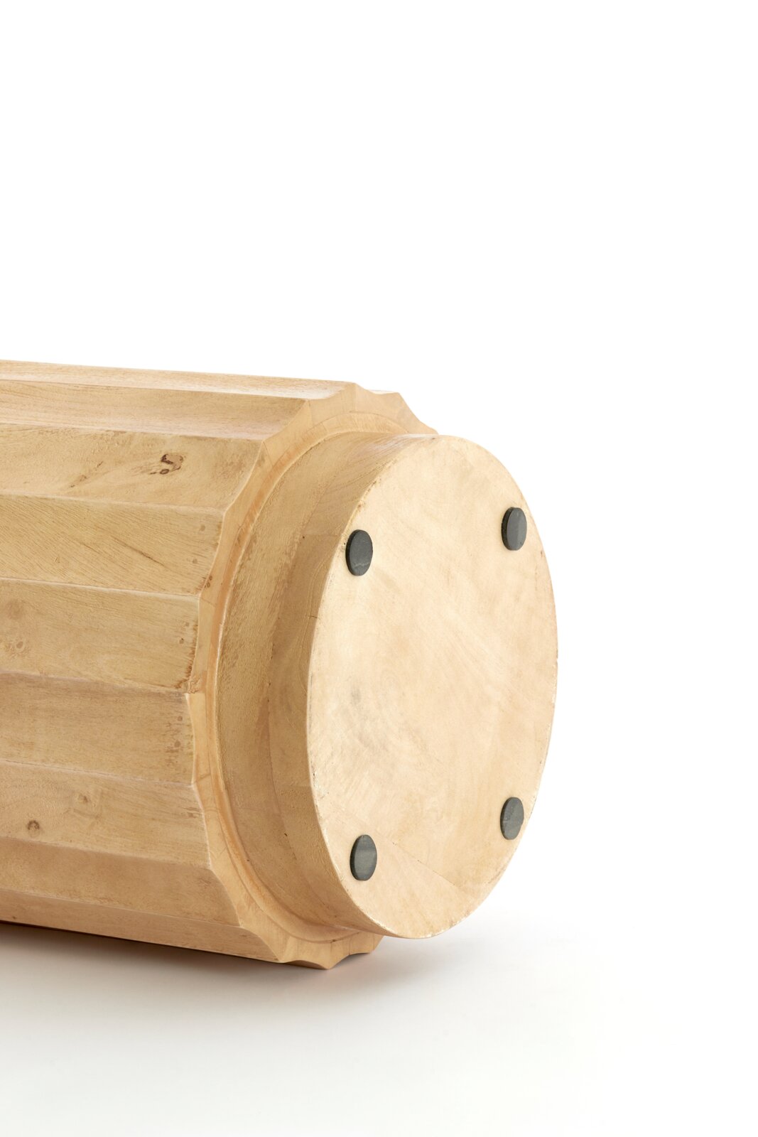 Unterseite eines hellen, gedrechselten Holzobjekts mit runder Bodenplatte und vier schwarzen Filzgleitern, Nahaufnahme in leichter Seitenansicht vor weißem Hintergrund