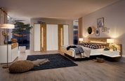 Komfortbett in modernem Schlafzimmer mit Holz- und Weißtönen, seitliche Perspektive