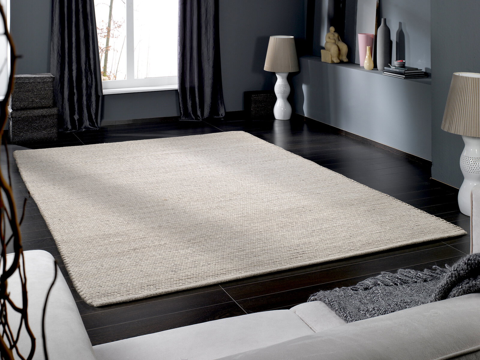 Handgewebter Teppich in einem modernen Wohnzimmer, aus der Perspektive eines Sofas fotografiert.