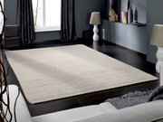 Handgewebter Teppich in einem modernen Wohnzimmer, aus der Perspektive eines Sofas fotografiert.