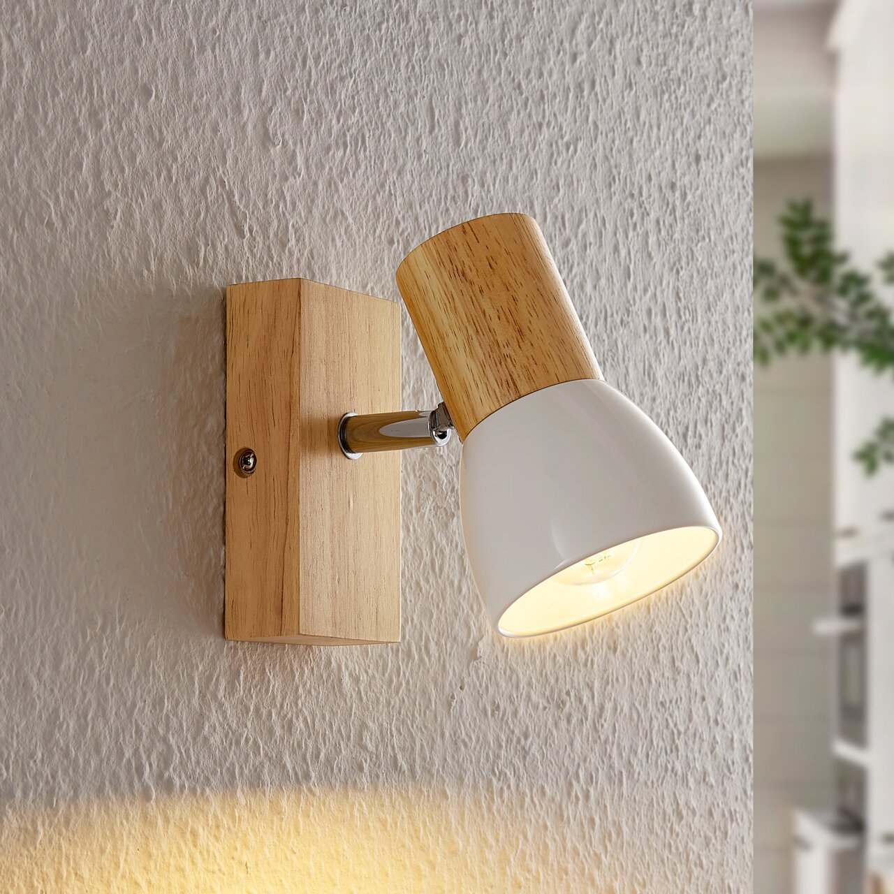 Wandstrahler aus Holz und Metall in Seitenansicht, eingeschaltet mit warmem Licht.