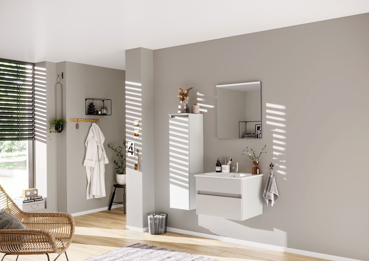 Moderne Badkombination aus der Serie NEXT4YOU von Puris, bestehend aus einem wandhängenden Waschtisch mit zwei Schubladen, einem großen Spiegel und einem hohen, schmalen Schrank. Die Perspektive zeigt das Set von vorne in einem hellen, stilvoll eingericht