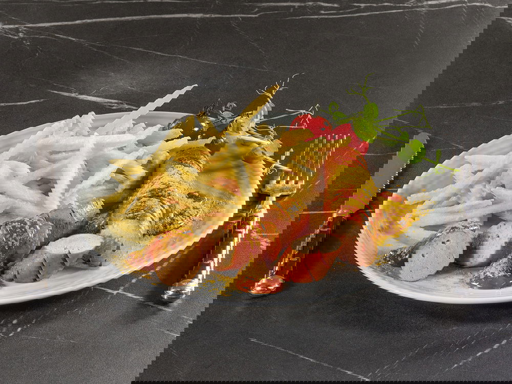 Currywurst mit Pommes auf Teller, mit Ketchup, Currypulver und Garnitur.