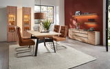 Moderne Esszimmeransicht mit zwei beleuchteten Vitrinen aus Holz, einem Esstisch mit vier braunen Stühlen und einem Sideboard vor einer roten Wand.