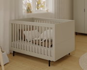 Modernes Kinderbett aus Holz in einem hellen Raum, seitliche Perspektive