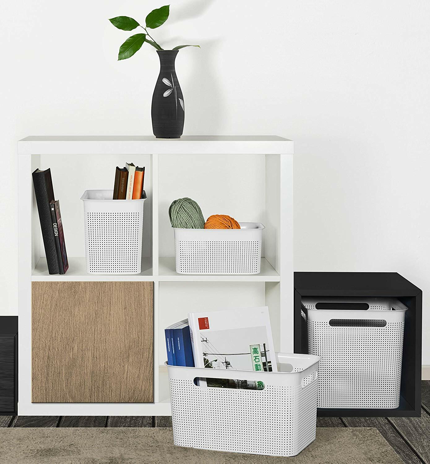 rotho Box BRISEN Weiße, schmale Aufbewahrungsboxen mit perforiertem Design, gefüllt mit Büchern und Garn, in einem modernen Regal von vorne betrachtet.