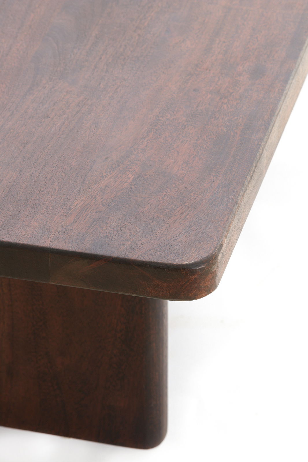 Nahaufnahme eines Couchtisches aus dunklem Holz mit abgerundeten Ecken, von oben betrachtet.