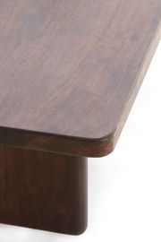 Nahaufnahme eines Couchtisches aus dunklem Holz mit abgerundeten Ecken, von oben betrachtet.