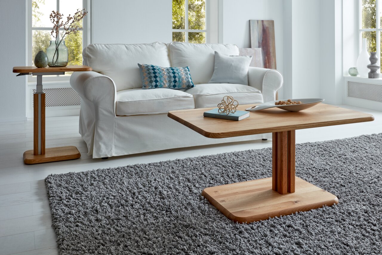Moderner Couchtisch aus Holz in einem hellen Wohnzimmer, frontal fotografiert, mit einem weißen Sofa im Hintergrund.