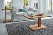 Moderner Couchtisch aus Holz in einem hellen Wohnzimmer, frontal fotografiert, mit einem weißen Sofa im Hintergrund.