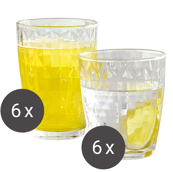 Zwei Gläser mit Rautenmuster, eines gefüllt mit gelbem Getränk, das andere mit Wasser und Zitronenscheibe, aus seitlicher Perspektive.