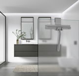 Grauer Duschabzieher aus Silikon, an einer Glasduschwand hängend, in einem modernen Badezimmer mit minimalistischer Einrichtung. Perspektive von der Seite.