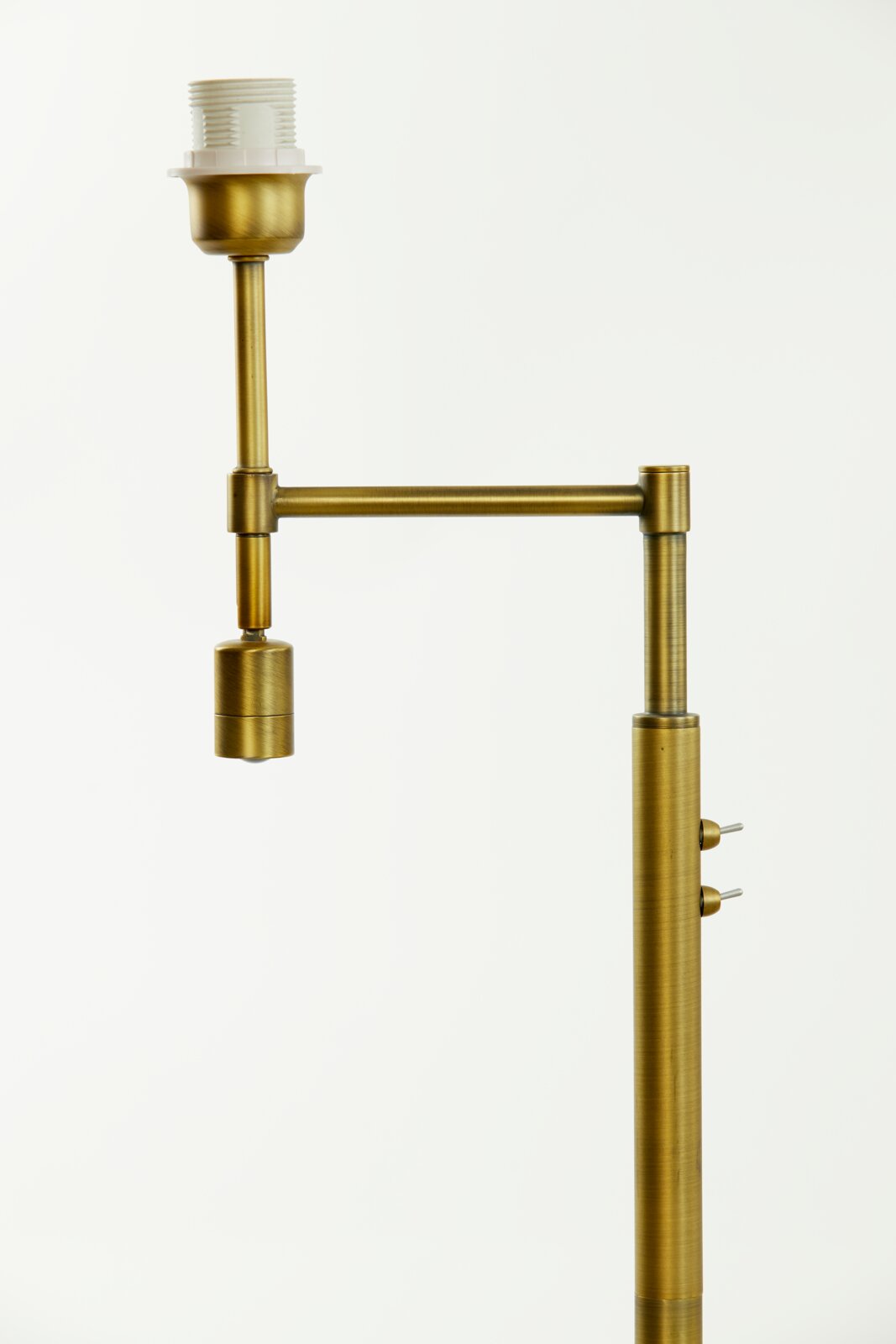 Detailfoto van een MONTANA-staande lamp in messinglook met verstelbare arm en schakelaar aan de zijkant.
