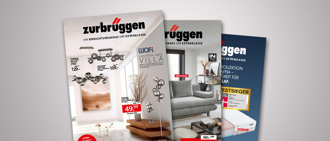 Drie catalogi van Zurbrüggen met aanbiedingen voor meubels en woonaccessoires liggen over elkaar heen.